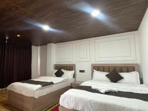 two beds sitting next to each other in a bedroom at Hotel khangyul in Ravangla