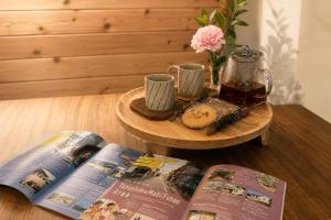 a wooden table with two pamphlets and a book at TOMOSHIBI Kurashiki Zen House Near Bikan Historical Quarter 美観地区近く 和モダン一棟貸し in Kurashiki
