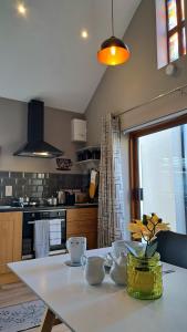 a kitchen with a table with cups and flowers on it at 9 Suíomh Alainn in Kilgarvan