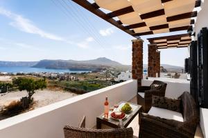 a balcony with a table and chairs and a view at Aelia Suites Akrotiri, Santorini in Akrotiri