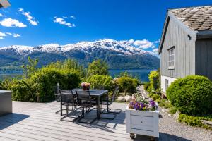 a wooden deck with a table and chairs and mountains at Villa Lilleheim in Breim