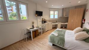a bedroom with a large bed and a kitchen at Apartamentos OKA Gernika in Guernica y Luno