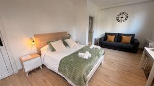 a bedroom with a large bed and a couch at Apartamentos OKA Gernika in Guernica y Luno