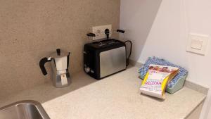 a kitchen counter with a toaster and a coffee maker at Apartamentos OKA Gernika in Guernica y Luno