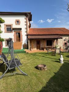 a house with a yard with a swing at Casa Mayucu in Celis