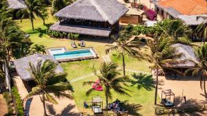 an aerial view of a house with a pool and palm trees at Pousada Casa Suiça in Itarema