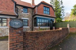 a brick wall in front of a house at Ty Mynydd Lodge Holiday Home in Cardiff