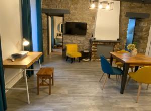 a living room with tables and chairs and a fireplace at residence fleurie rdc in Saint Malo