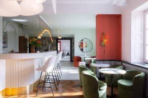ein Restaurant mit einer Bar mit grünen Stühlen und Tischen in der Unterkunft Hotel 2M, The Originals Relais in Saint-Rambert-sur-Loire