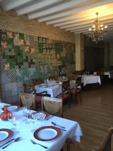 a dining room with white tables and chairs and a chandelier at Hotel La Villoría in Medina Sidonia