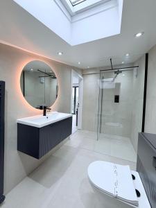 a bathroom with a toilet and a sink and a mirror at Woodroyd Spa Suites in Luddenden Foot +39 photos