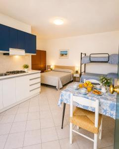 a kitchen and a bedroom with a bed and a table at Residence Mediterraneo - Agenzia Cocal in Caorle