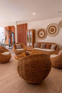 a living room with wicker chairs and a table at Refugio urbano in Nuevo Cuscatlán