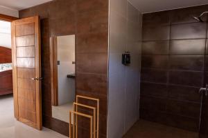 a bathroom with a shower with a glass door at Refugio urbano in Nuevo Cuscatlán +63 photos