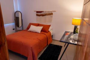 a small bedroom with a bed and a mirror at Refugio urbano in Nuevo Cuscatlán