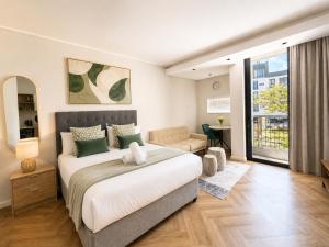 a bedroom with a large bed and a living room at On Park Luxury One Bed & Bath- in Cape Town