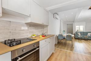 a kitchen with white cabinets and a living room at Apartment Katja in Vantačići