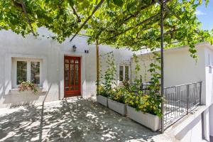 a white house with a red door and some plants at Apartment Katja in Vantačići