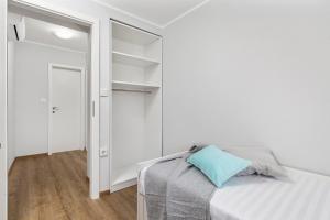 a bedroom with white walls and a bed with a blue pillow at Apartment Katja in Vantačići