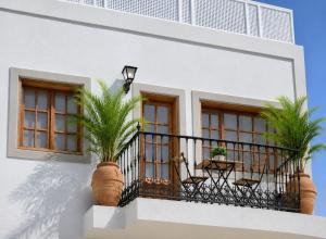 a white building with a balcony with palm trees on it at Deluxe Mogán Beach Apt 1 in Puerto de Mogán