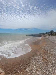 a beach with a cloudy sky and the ocean at Vinaros Modern Apartment in Vinarós