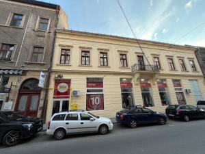 a white car parked in front of a building at WOT Rose Residence in Arad