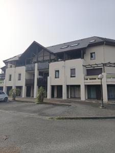 a large white building with a car parked in front at Appartement T1 et petite terrasse in Artiguelouve