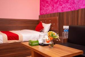 a bedroom with a bed and a table with flowers on it at Hotel Ram Janaki in Janakpur
