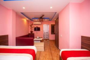 two beds in a room with pink walls at Hotel Ram Janaki in Janakpur