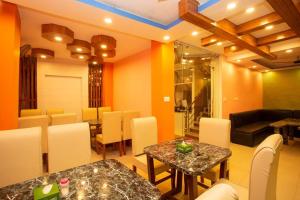 a dining room with two tables and a couch at Hotel Ram Janaki in Janakpur