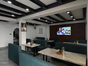 a restaurant with tables and chairs and a tv on the wall at Hotel khangyul in Ravangla +20 photos