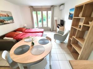 a living room with a table and a couch at Barcaresa - Malibu village Catalan T2 terrasse in Canet-en-Roussillon