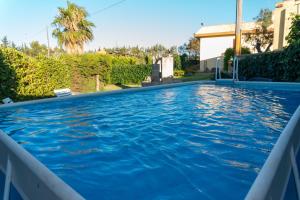 a swimming pool with blue water in a yard at Casa Vacanze Il Sole in Casamassella