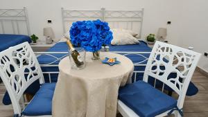 a table with a vase of blue flowers on it at Alba Ionica Taranto in Taranto