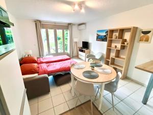 a living room with a bed and a table and chairs at Barcaresa - Malibu village Catalan T2 terrasse in Canet-en-Roussillon