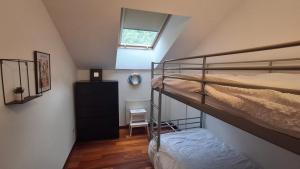 a attic room with two bunk beds and a mirror at Ca Na Daniela in Carreña de Cabrales