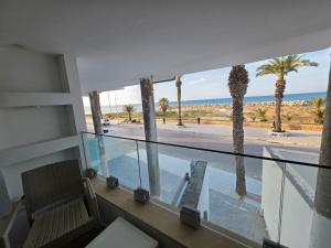 a balcony with a view of the ocean and palm trees at Dar Julia Seaview Apartment in Mahdia