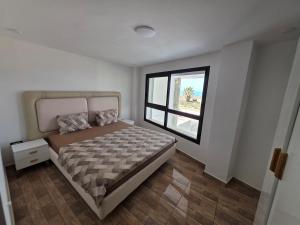a bedroom with a large bed and a window at Dar Julia Seaview Apartment in Mahdia