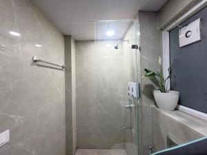 a bathroom with a glass shower with a plant in it at The verdant corner in Gurgaon