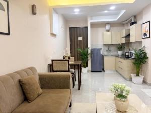 a living room with a couch and a kitchen at The verdant corner in Gurgaon