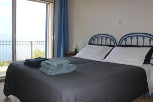 a bed with a suitcase on top of it with a window at Villa Torre in Acquafredda