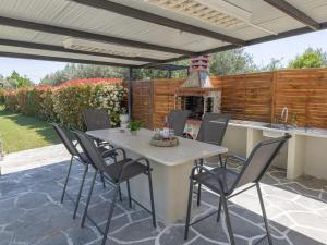 a patio with a table and chairs and a kitchen at THAλEIA Holiday Home in Nea Kallikrateia