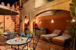 a patio with a table and chairs and a staircase at Riad FARASHA & Pool-Rooftop View in Marrakesh