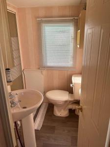 a small bathroom with a toilet and a sink at GnT Caravan lets in Anderby