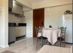 a dining room with a table and chairs in a kitchen at Loft aconchegante no Centro in Joinville