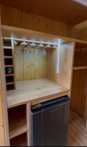 a small kitchen with wine glasses and a refrigerator at Glamping&BBQ San José - Susa Cundinamarca in Susa