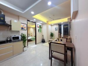 a kitchen and living room with a table and a microwave at The verdant corner in Gurgaon +46 photos