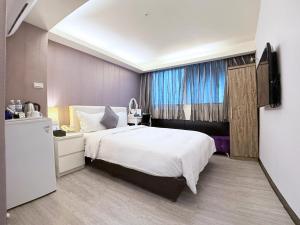 a bedroom with a large white bed and a window at 意芙旅店 Ifinn Hotel in Taipei