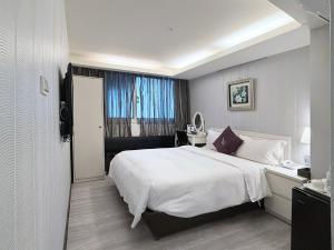 a bedroom with a large white bed and a window at 意芙旅店 Ifinn Hotel in Taipei