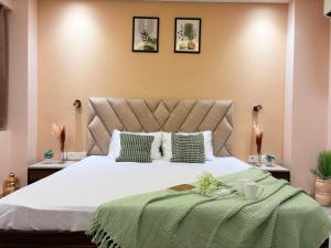 a bedroom with a large bed with a green blanket at The verdant corner in Gurgaon